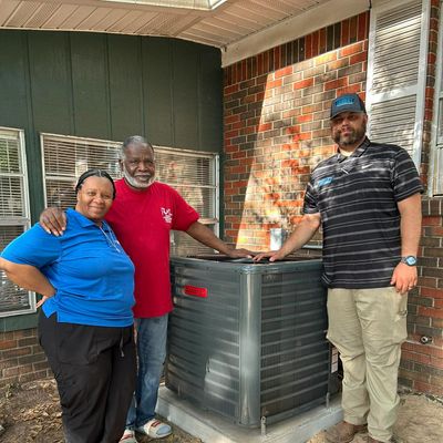 Customer and service provider smiling in front of a new unit