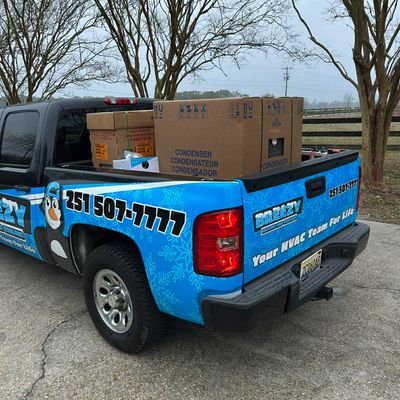 Breezy service truck carrying HVAC equipment with phone number showing on the side. 