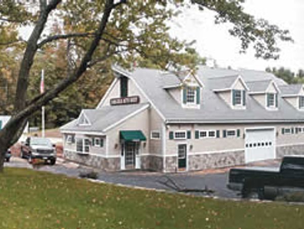 A quaint building with dormer windows and a green awning.