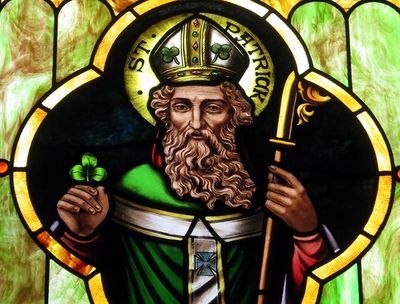 Stained glass image of St. Patrick holding a shamrock.