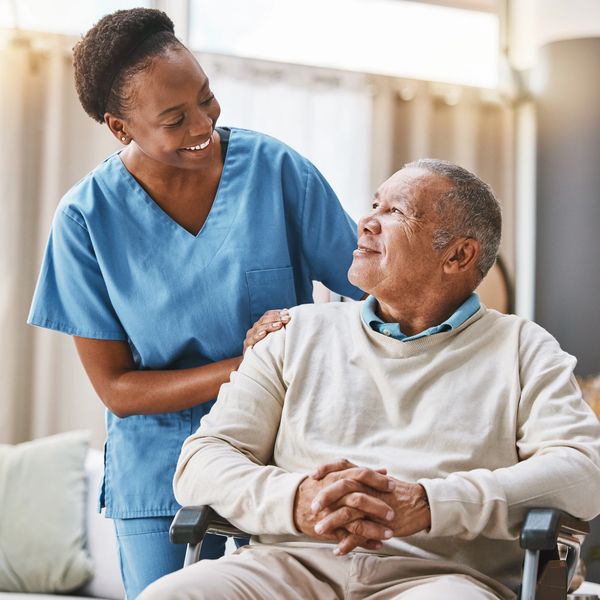 A nurse helping an elderly man