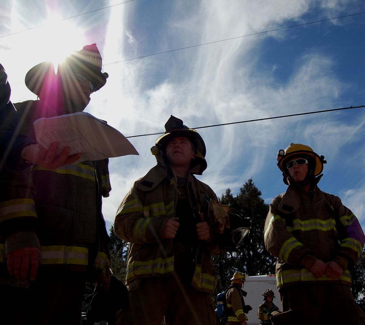 Firefighters standing with sun rays shining over them