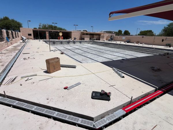 A partially constructed outdoor swimming pool under clear sky.