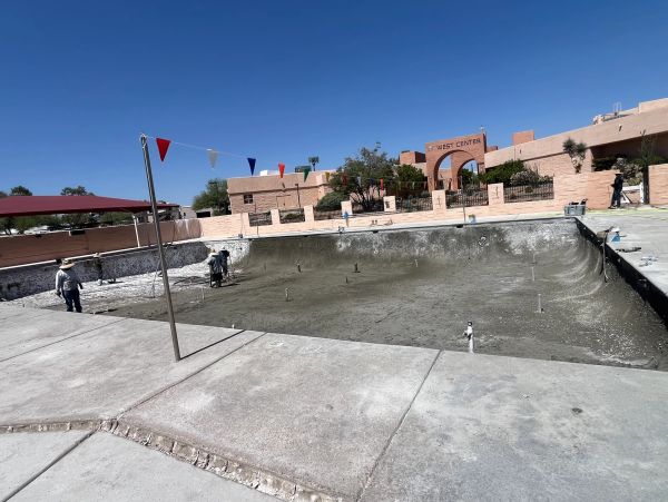 Empty pool under construction with workers.