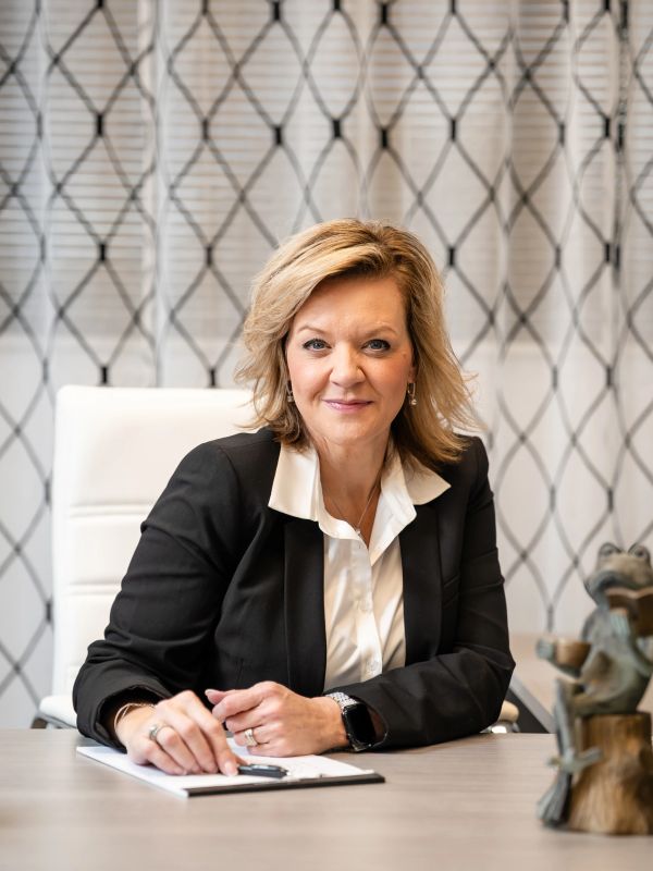 Professional woman sitting at office desk smiling.