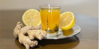 Fresh ginger and lemon with a cup of tea on a wooden table