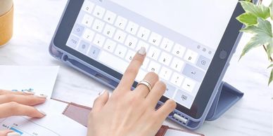 Person using a tablet with keyboard while working from home