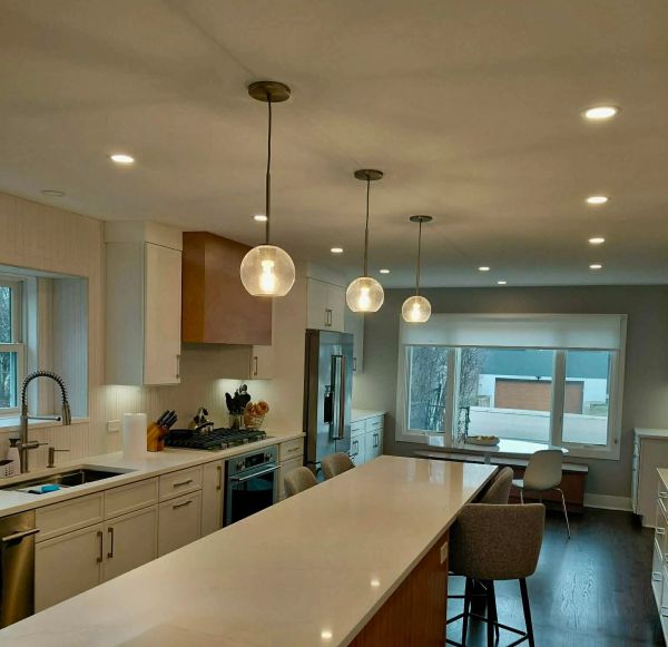 Modern kitchen with white countertops and pendant lighting.