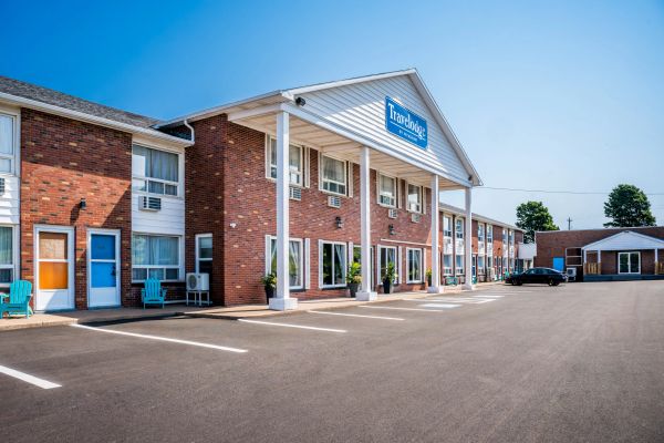 Exterior view of a Tradologie hotel building with empty parking spaces.