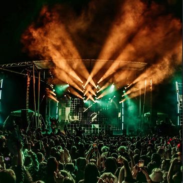 Crowd enjoying a concert with dramatic stage lighting.