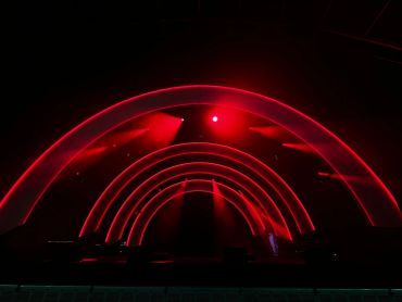 Red neon arches glowing in a dark setting.