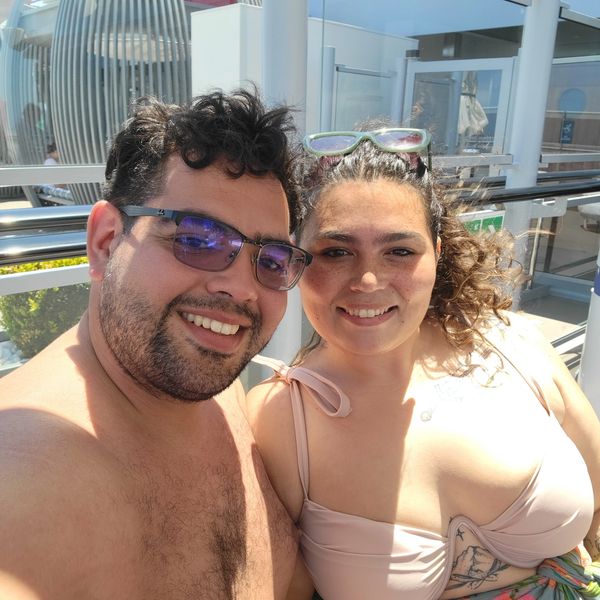 A happy couple enjoying a sunny day outdoors, smiling at the camera.