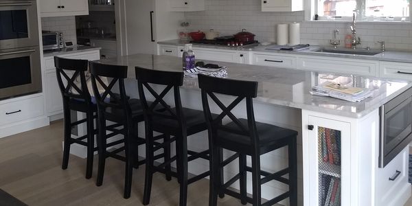 A view of Kitchen with Black chair On the dining table