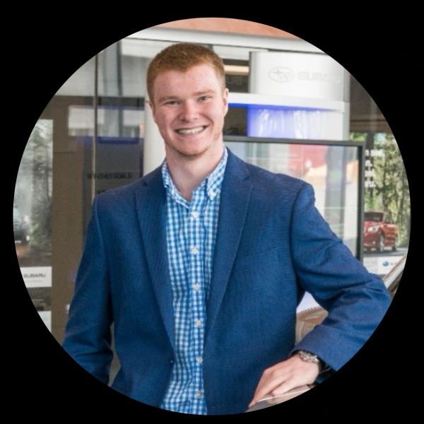 Young man in a blue blazer smiling.