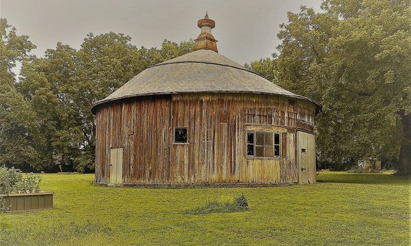 Round Barn in a green field with trees