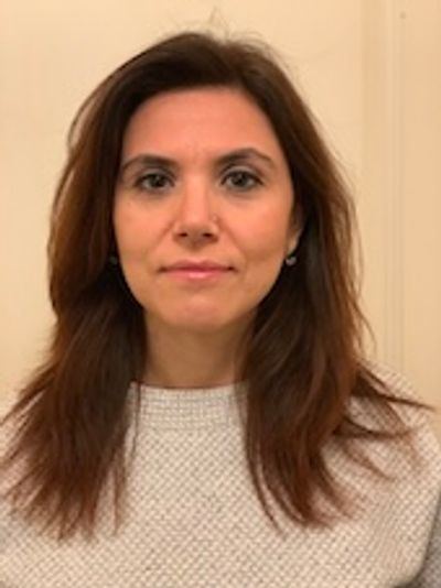 Portrait of a woman with brown hair and a white sweater.