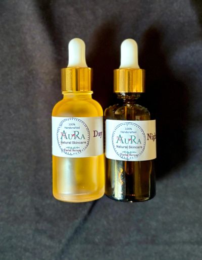 Two Aura Natural Skincare facial serum bottles labeled Day and Night.