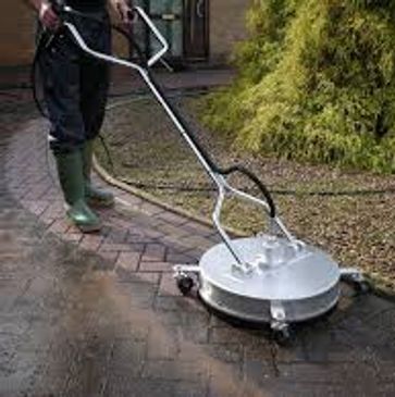 Person using a surface cleaner to wash a brick patio.