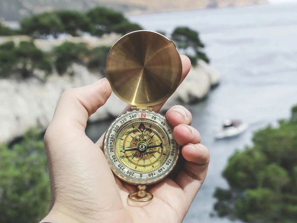 Compass held in hand giving a person guidance - support much like coaching.