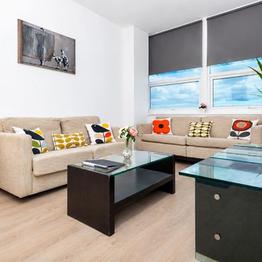 Bright living room with beige sofas and colorful cushions.