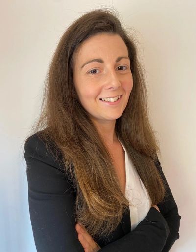 Smiling woman with long brown hair in professional attire.