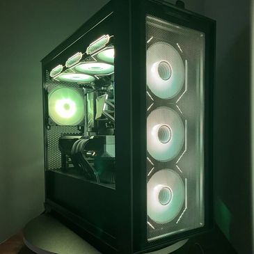 Black PC tower with glowing green cooling fans inside and on front mesh panel.