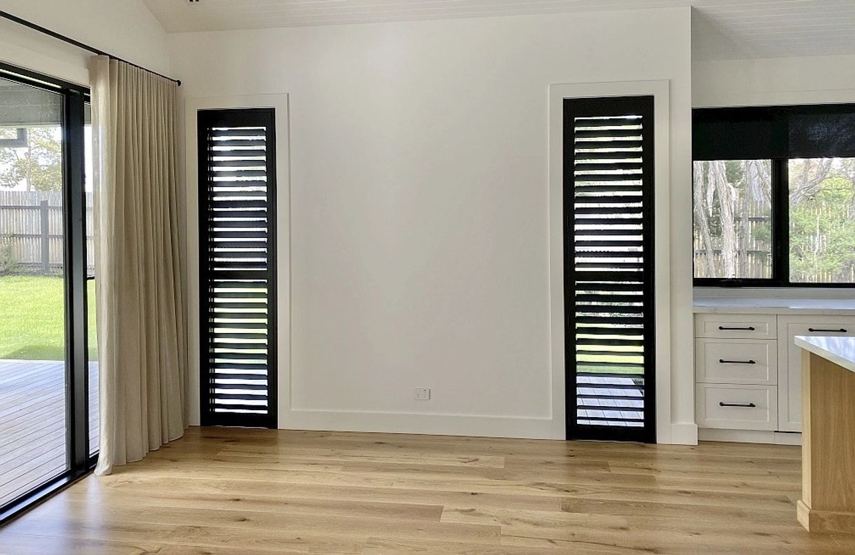 Modern black indoor aluminium shutters installed in a living room