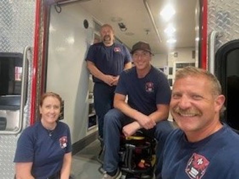 KCFD1 employees smiling from the back of the ambulance