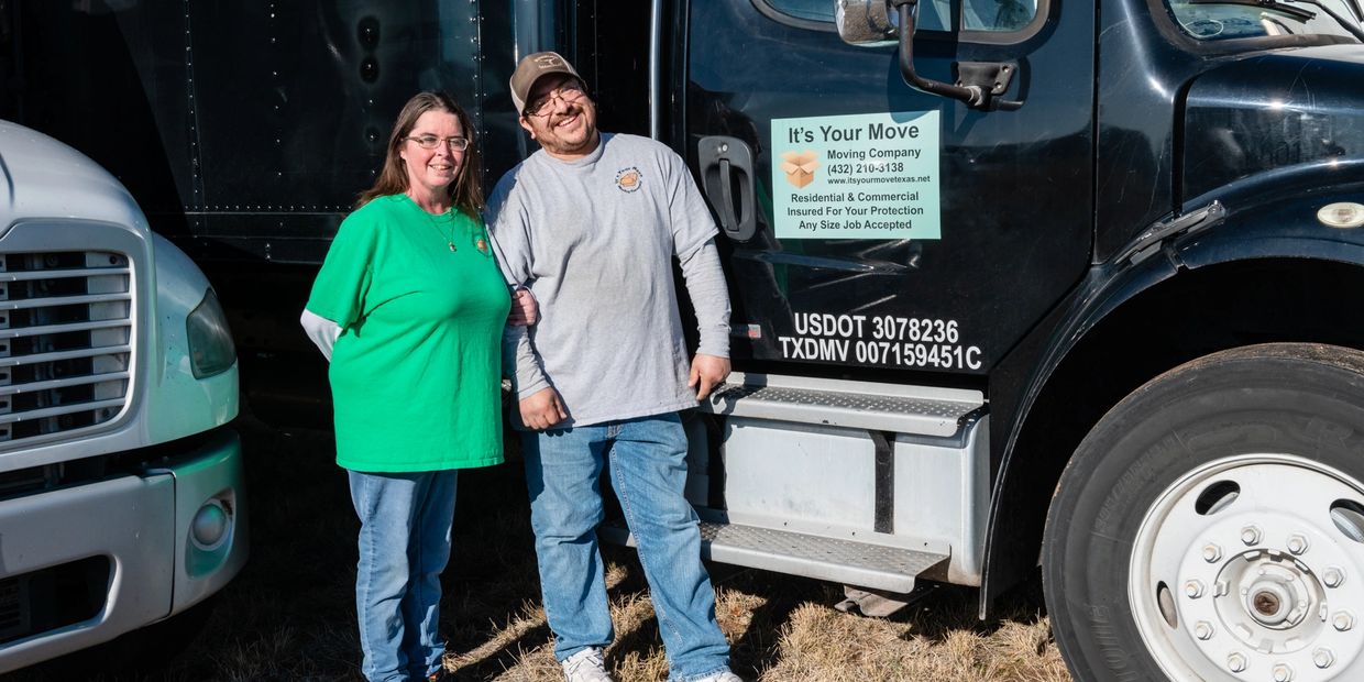 a man and a woman standing near a truck 