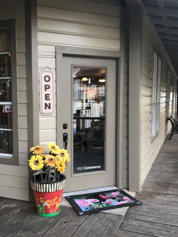 Entrance of a quaint shop with sunflowers and an open sign.