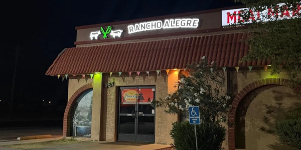Night view of Rancho Alegre Mexican restaurant with illuminated sign and parking spot.