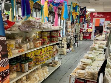 A grocery store aisle filled with various packaged food items and tortillas.