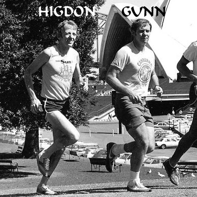 Two men jogging outdoors near the Sydney Opera House in black and white.