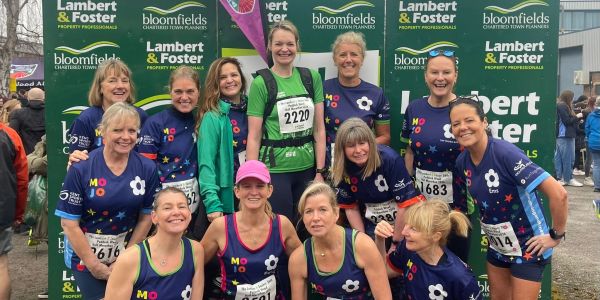 Group of women runners posing joyfully after a race event.