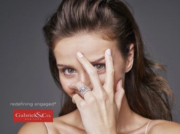 Woman partially covering her face with a hand, showing rings.