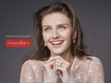 Smiling woman showing an engagement ring.