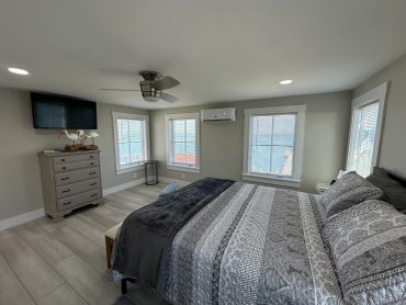 Modern bedroom with large bed and dresser.