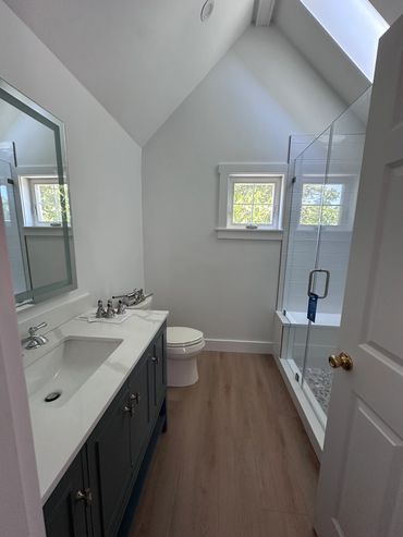 Modern bathroom with dual sinks and glass shower.