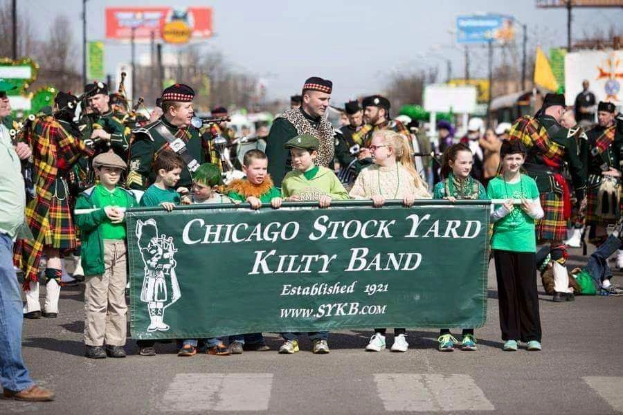 Children and men in kilts at Chicago Stock Yard Kilty Band parade.