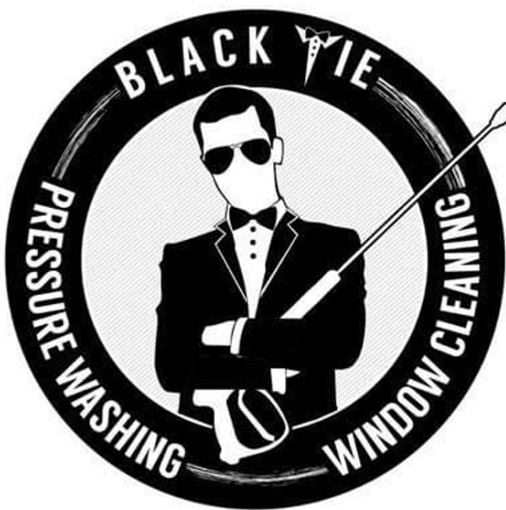 male holding a pressure washing gun wearing a tuxedo with a bow tie and glasses