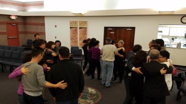 People gathered indoors, engaging in group dancing or social interaction.