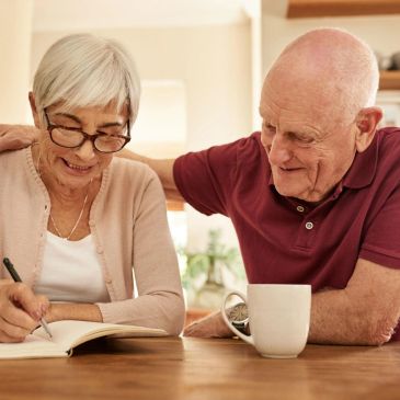 Elderly couple sharing a moment at a table.