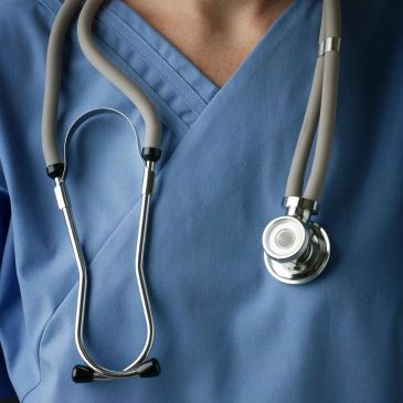 Doctor in blue scrubs with stethoscope.