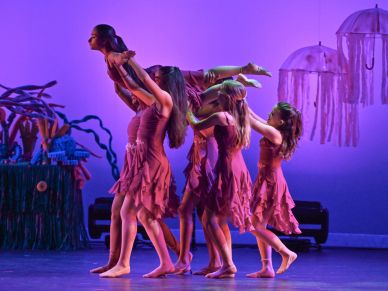 Young dancers performing contemporary dance in pink dresses.