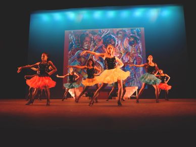 Ballet dancers performing on stage with colorful costumes.