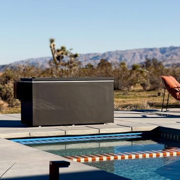 Modern poolside storage box with desert landscape in the background.