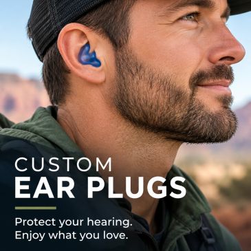Man wearing custom blue ear plugs outdoors.