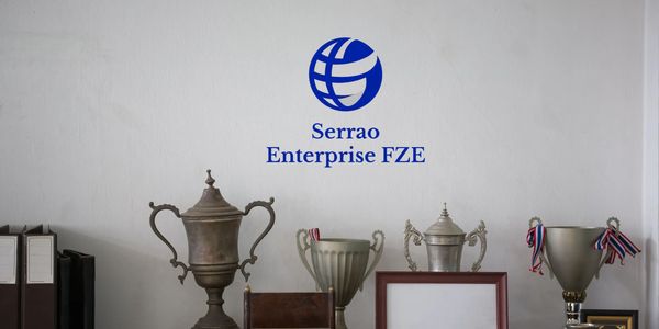 A collection of trophies and awards displayed on a wooden shelf under the Serrao Enterprise FZE logo.