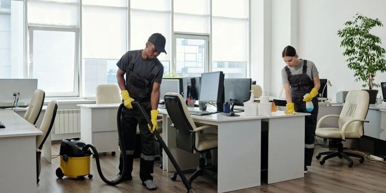 Two janitors cleaning an office space.