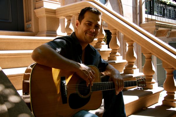 Derek Samuel Reese with his guitar photo shoot on a stoop in Brooklyn Heights